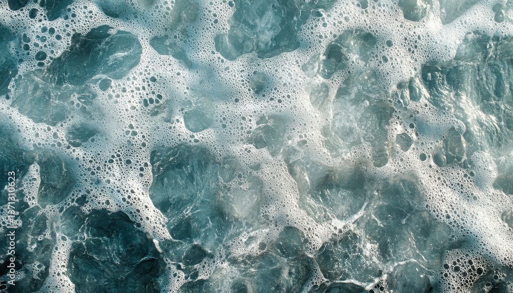 Aufkleber bubbling foam and gentle waves meeting the sandy shore during a bright afternoon on a tranquil beach