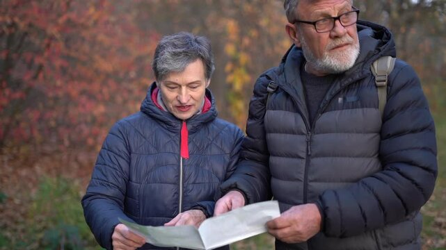 Beautiful retired couple looking at map and planning tourist route. People over 60, aging youthfully