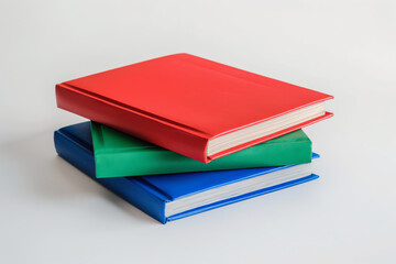 Colorful stack of books in red, green, and blue with blank covers on a plain background