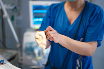 Nurse putting on sterile gloves in hospital room