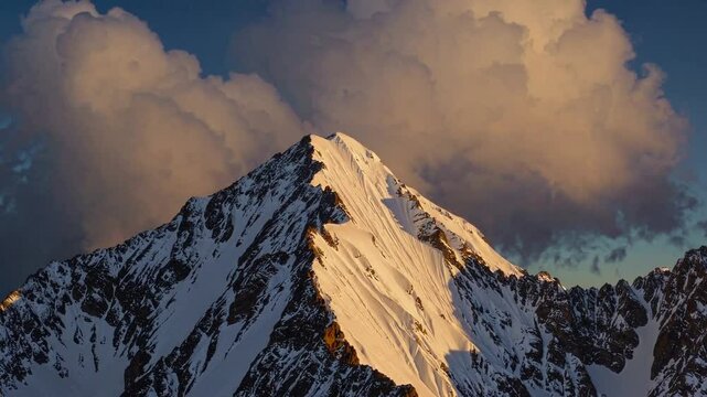 Majestic Khan Tengri Mountain Peaks Glowing Against Sunset Clouds  