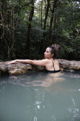Fototapeta premium girl enjoying thermal wather in tropical forest