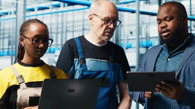 Engineers talking with manager overseeing smart factory, showing collected metrics. Technicians receiving feedback from supervisor in industry 4.0 industrial plant equipped with sensors, camera A