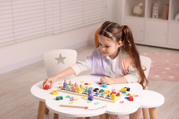 Motor skills development. Little girl playing with math game Fishing for Numbers at white table...