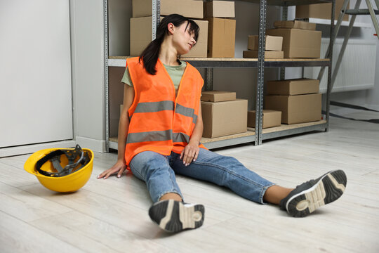 Accident at work. Unconscious woman on floor in warehouse