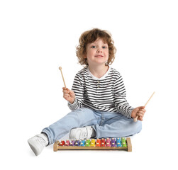 Cute little boy playing toy xylophone on white background