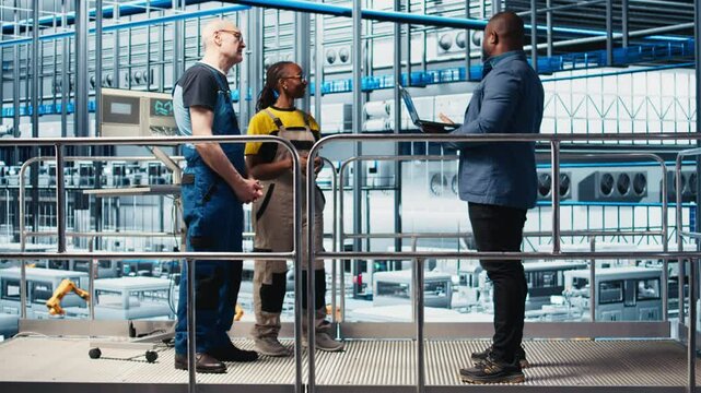Investor visiting industry 4.0 solar panels plant, talking with engineers to ensure limited downtime before investing. Photovoltaics smart factory shareholder checks work done by technicians, camera A