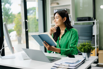 Young attractive Asian female office worker business suits smiling in office .