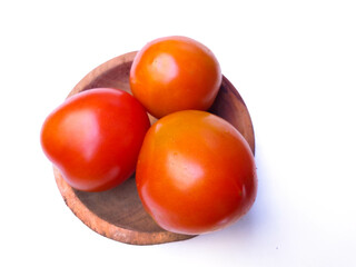 Fresh ripe tomatoes in a wooden bowl, perfect for food photography and culinary use.