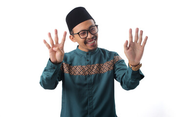 Excited Asian Muslim man raising nine fingers with a bright smile, making a number nine or...