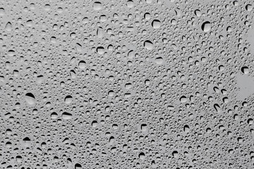 Water drops on grey glass surface, top view