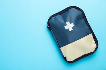 First aid kit on light blue background, top view. Space for text