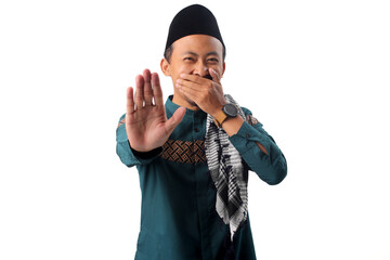 Asian Muslim man covers his mouth while showing a stop gesture, symbolizing self-restraint and...