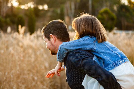 Father giving daughter a piggy back ride