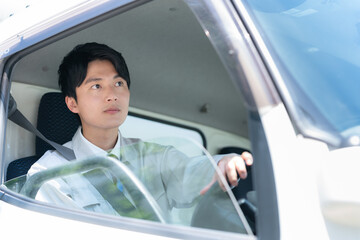 トラックを運転する若い男性ドライバー