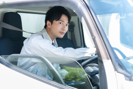 トラックを運転する若い男性ドライバー