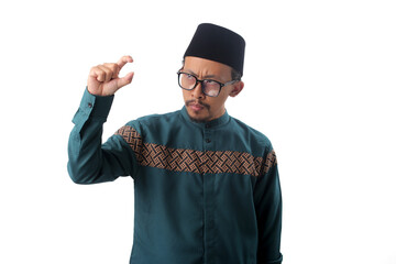 Displeased Asian Muslim man gesturing with his hand, making a small size sign to indicate something is small or unsatisfactory. Isolated on a white background.