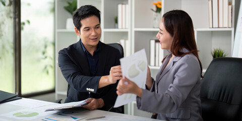 Professional Interaction and Financial Reporting. Colleagues exchanging insights while reviewing financial materials.