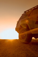 sunset in the desert with an offroad vehicle