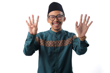 Excited Asian Muslim man raising nine fingers with a bright smile, making a number nine or...
