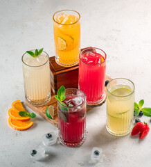 Five different glasses of lemonade on the table, drinks with berries and citrus fruits