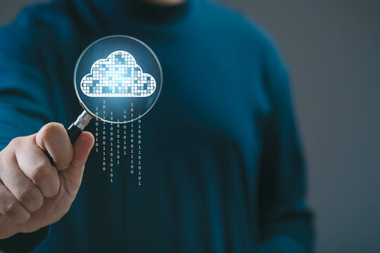 A person holding a magnifying glass displaying a digital cloud icon. Represents cloud computing, data storage, and technology innovation. - Powered by Adobe