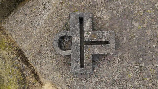 Tzompantli sacrificial altar as ankh cross at the archaeological site of Calixtlahuaca in Mexico. Overhead drone camera hovering over the altar