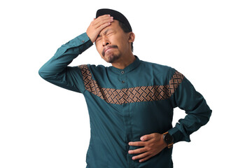 Asian Muslim man experiencing dizziness and stomach pain, holding his head and abdomen, isolated...
