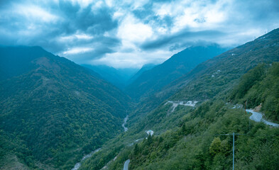 Obraz premium Misty Mountain Valley with Winding Road – Arunachal Pradesh, India
