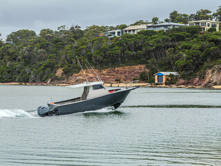 Obraz premium Original name(s): Dark Hulled Boat Motors Into The Rive