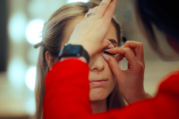 Woman Gets Professional Makeup and False Eyelashes Applied. Woman getting her makeup done by a...