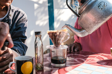 People morning talk with drip brewing coffee by paper filtered on table