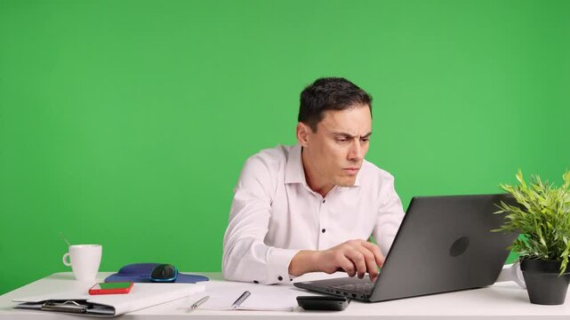 Office worker reacting with surprise and perplexity at laptop on green screen