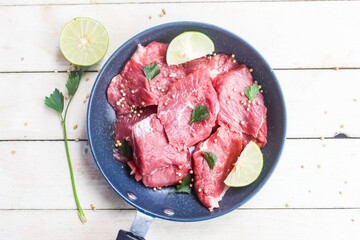 Raw uncooked meat pieces in a pan with spices