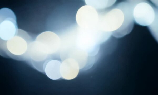 Abstract elegant particles of light and glitter. Flying luminous beautiful dots creating bokeh. seamless loop