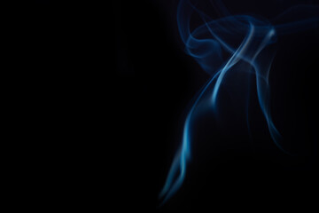 Delicate blue smoke swirls gracefully against a dark background, creating an abstract and ethereal visual effect with fluid motion. Swirling, writhing smoke to overlay