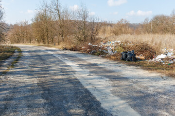 An illegal dump in a natural area near a road