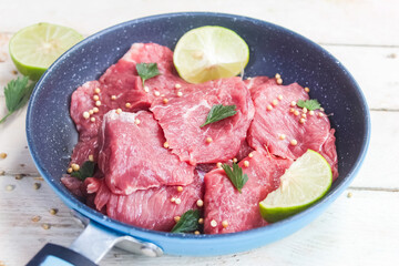 Raw uncooked meat pieces in a pan with spices