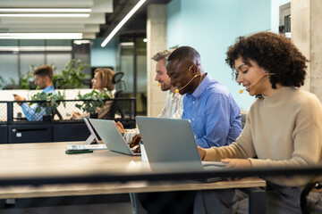 Happy young male customer support executive working in office.