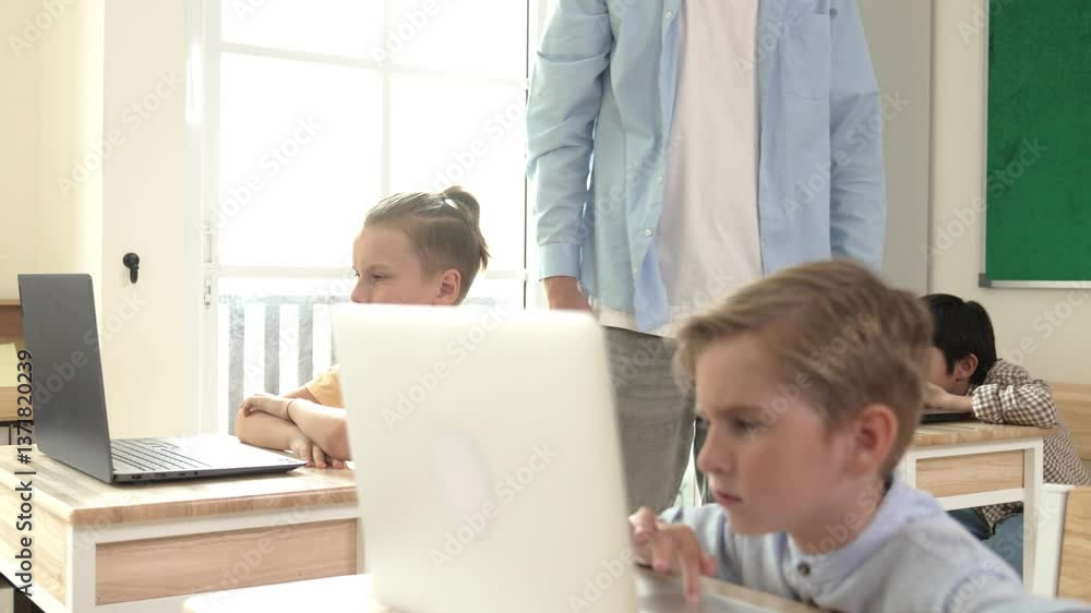 Poster caucasian teacher helping american student coding engineering prompt while diverse student using sof