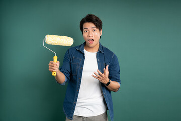 "Portrait of an Asian male painter posing against a green background."