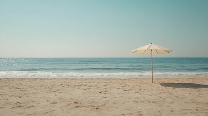 Fototapeta premium Serene Beach Scene Sandy Shore with Single Beach Umbrella and Calm Ocean Waves