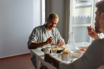 Gay couple enjoying breakfast at home together