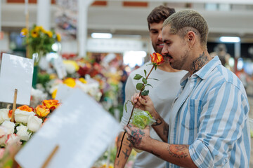 Happy gay couple choosing flowers at a flower market