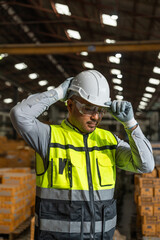 Close up technician engineer wearing and adjust protective safety helmet or hard hat. Safety...