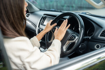 Hand woman pushing car horn while driving car.