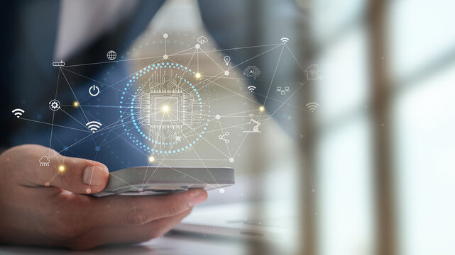 Industrial IoT and AI based technology concept with human hand using mobile device to manage smart automation, cloud network, and digital data flow for intelligent business operations
