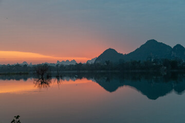 Golden Dawn on Li River: Misty Karst Peaks Reflecting in Mirror-Still Waters &ndash; Guilin's Ethereal Morning Symphony