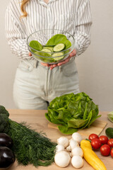 Happy slim woman with a bowl of salad in her hands. Woman preparing salad