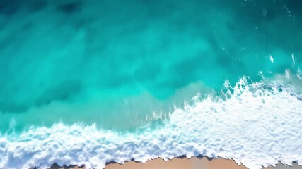 Aerial top down view of turquoise ocean waves crash on sandy beach. Top view footage of clear aqua sea water, white foam surf rolling onto coast. Sea background, relaxing summer travel vibe